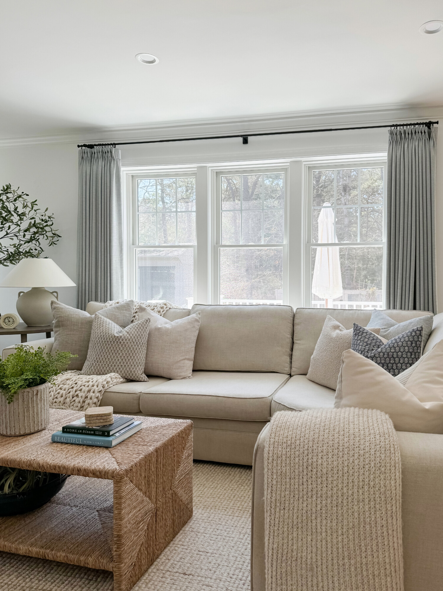 beige sectional with woven coffee table and coastal accents