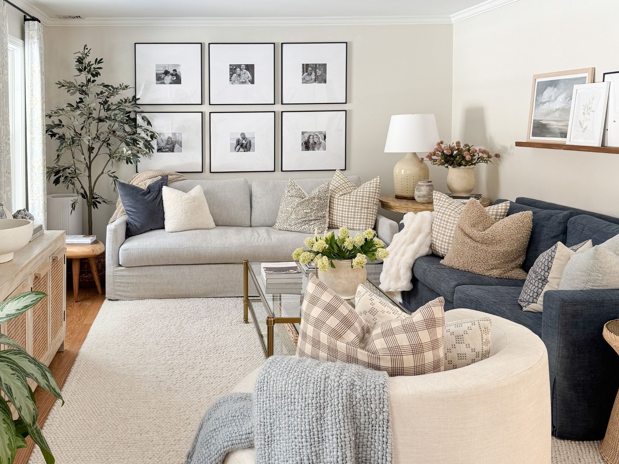 Coastal inspired living room with neutral sofas, textured Amazon throw pillows, plush ivory area rug, and faux floral coffee table styling for a high end coastal home look.